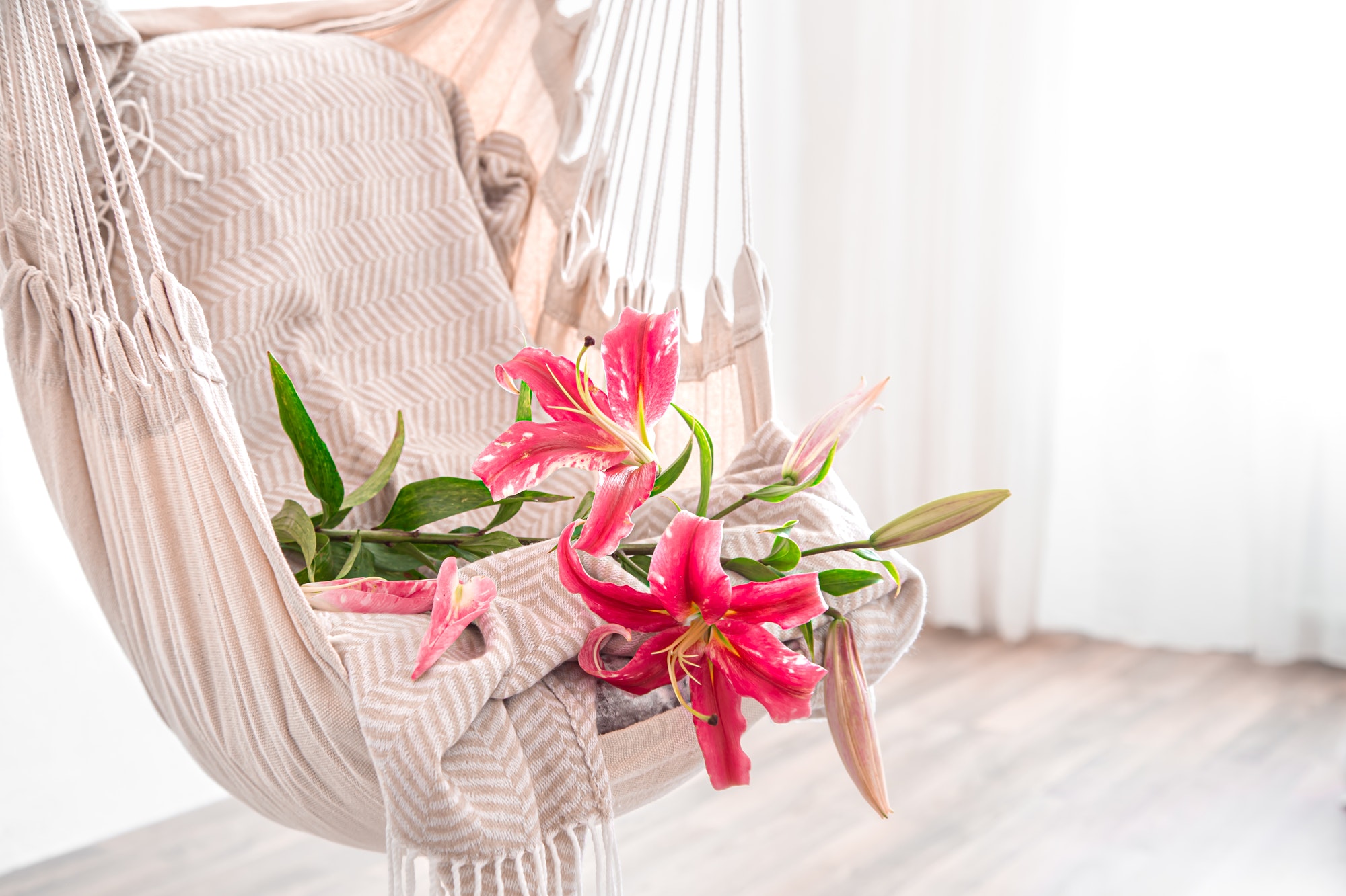 A hammock chair in boho style, with beautiful Lily flowers.